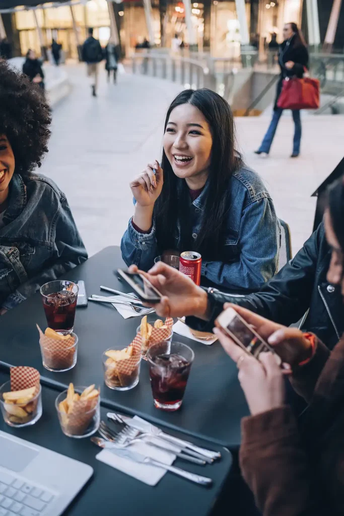 Friends sharing snacks at a shopping centre food court table